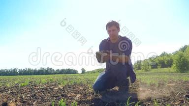 一个农民工人手里握着新鲜的土壤。 慢动作视频。 人的地面泥土保持泥土春天的象征